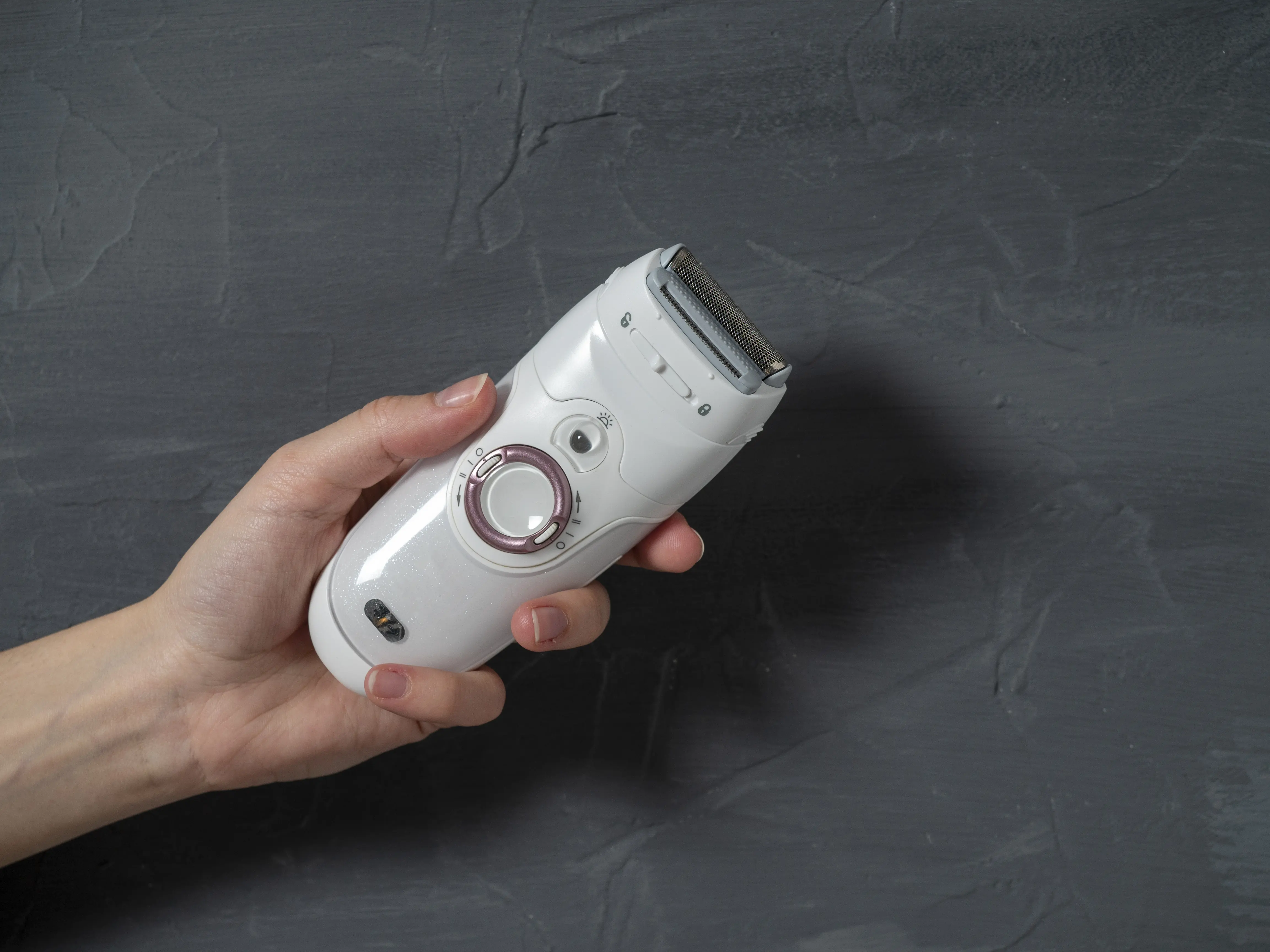 Closeup Female Electric Epilator Female Hand Gray Textured Background